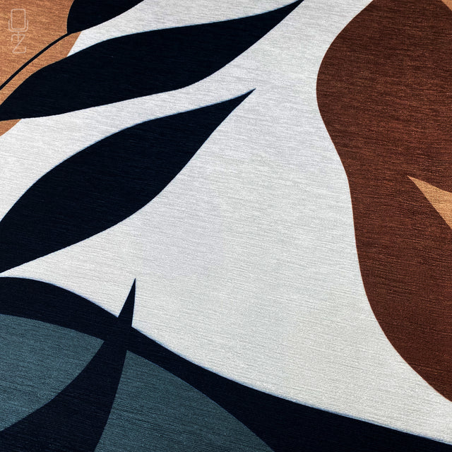 Zoomed-in view of brown, black white and beige leaf themed printed cushion cover.