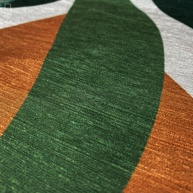 Zoomed-in view of green and orange leaf-themed printed pillow cover.